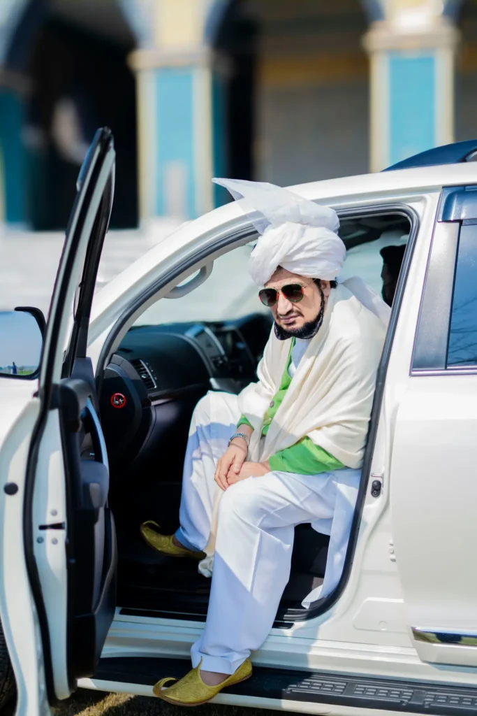 Sultan-ul-Ashiqeen sitting at car entrance.